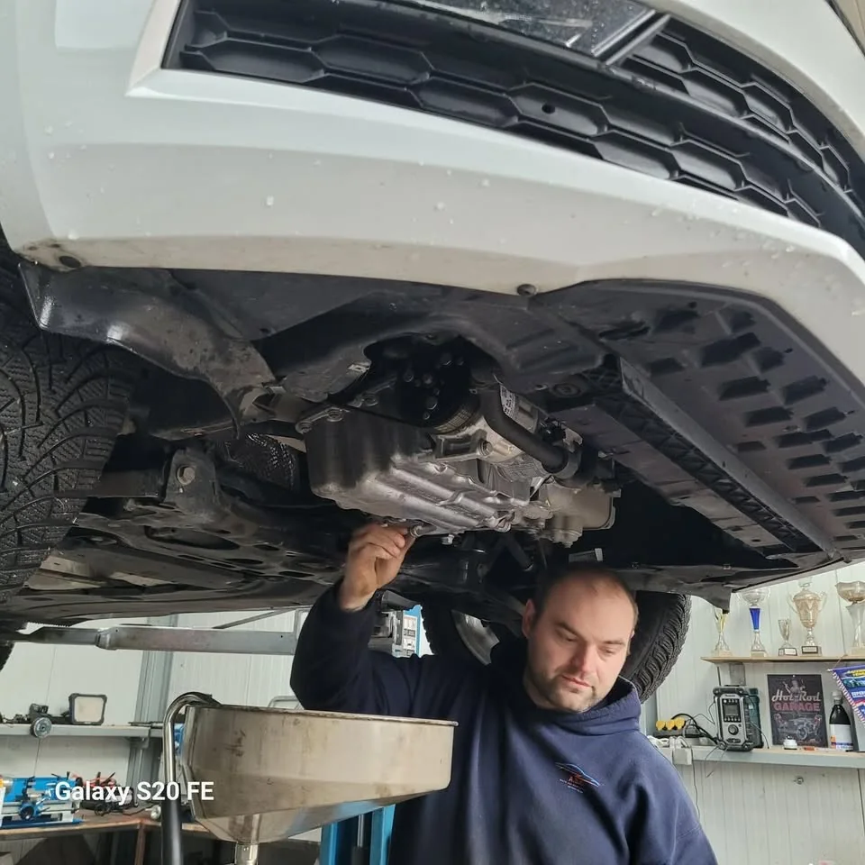 Glenn Verhulst voert onderhoud uit onder een wagen